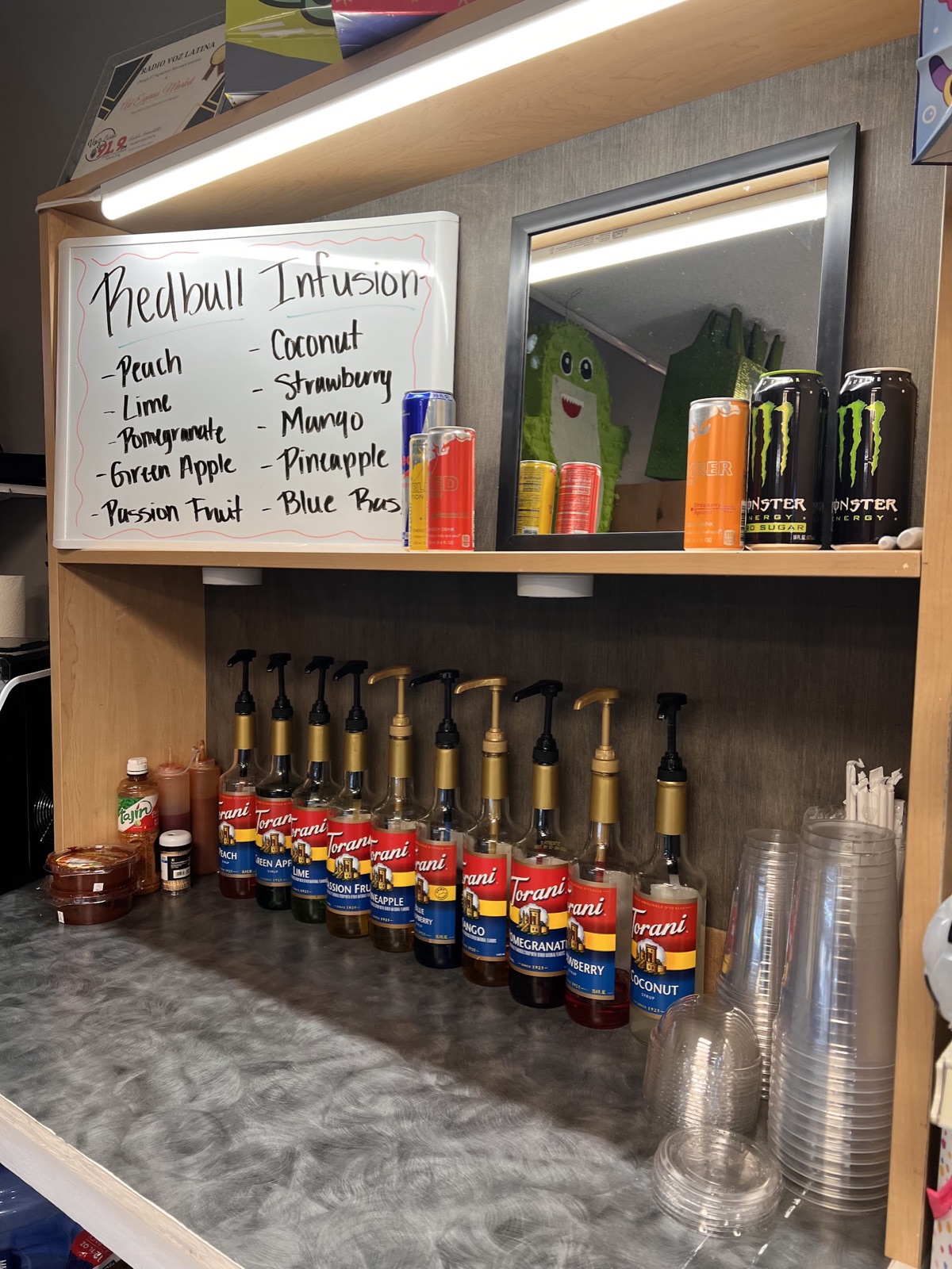 Drink bar with Torani syrups, Tajín, and a whiteboard listing Red Bull infusion flavors