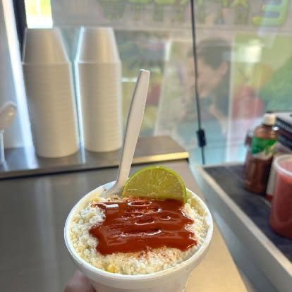 Esquites with salsa and lime at the counter