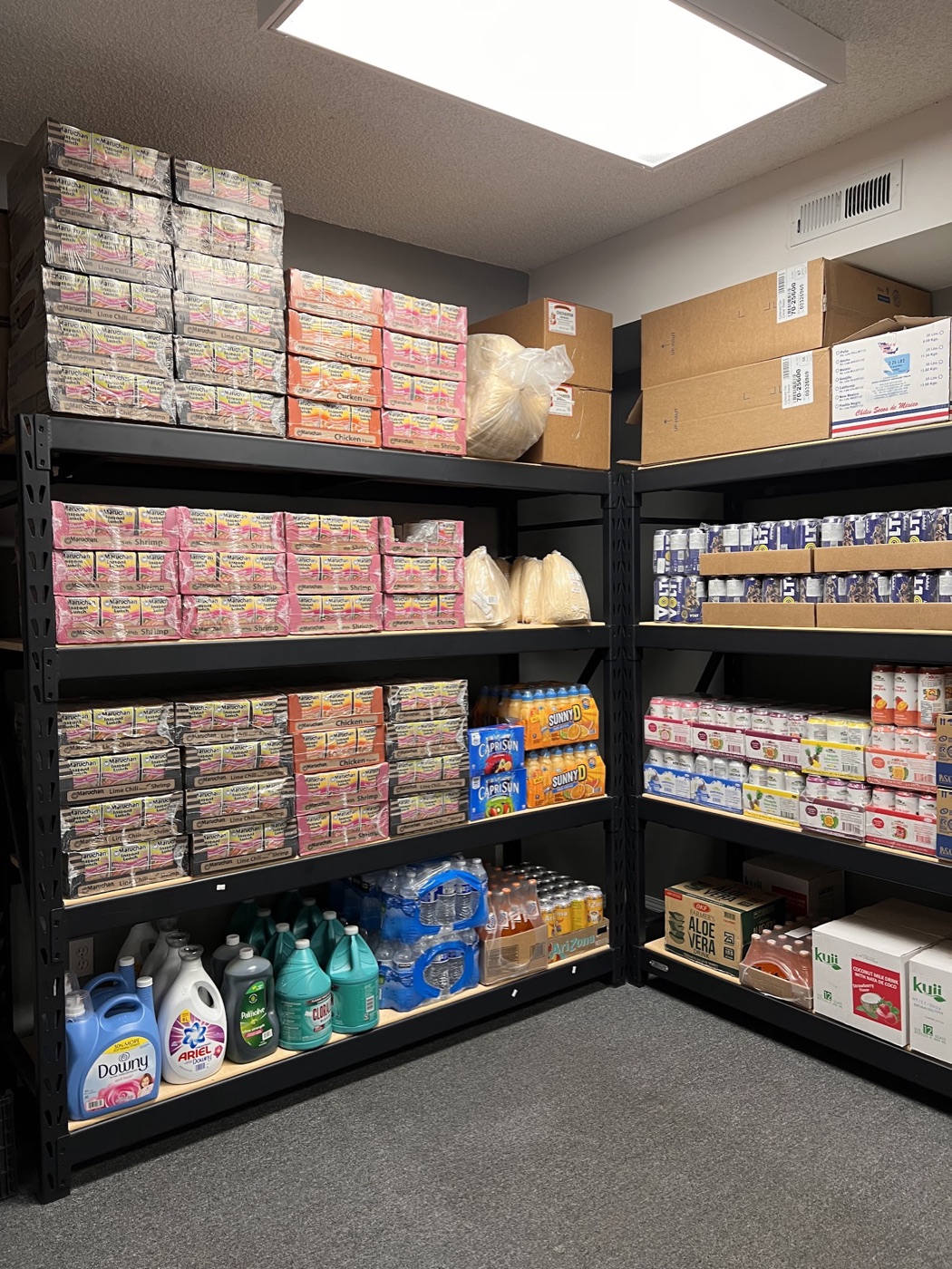 Shelves stocked with Maruchan, Sunny D, Capri Sun, drinks and household cleaning supplies